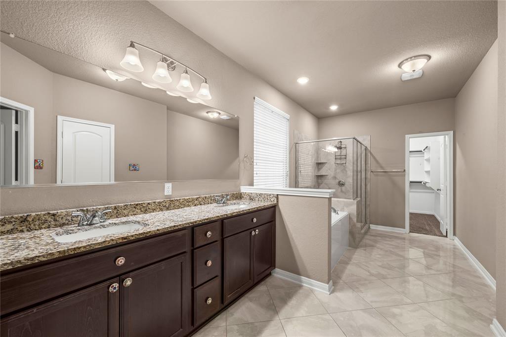 10420 Langham Drive Waco, TX 76708 - Photo 16 of 36 a bathroom with a granite countertop sink a large mirror and a shower