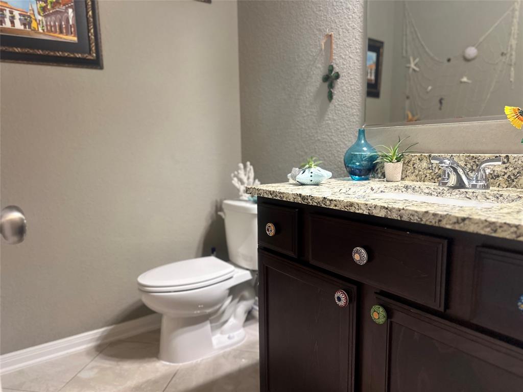 10420 Langham Drive Waco, TX 76708 - Photo 19 of 36 a bathroom with a granite countertop sink a toilet and a mirror