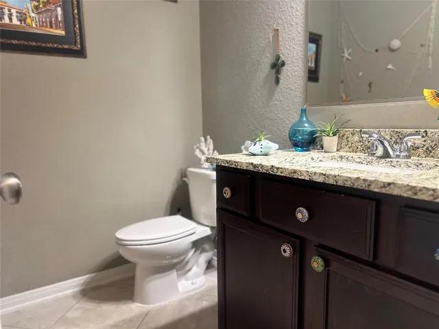a bathroom with a granite countertop sink a toilet and a mirror