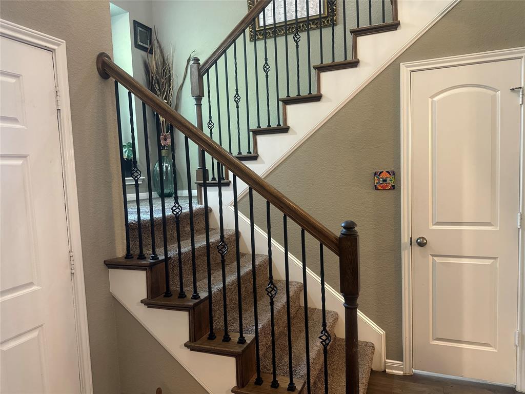 10420 Langham Drive Waco, TX 76708 - Photo 20 of 36 a view of staircase with lots of frames on wall and wooden floor