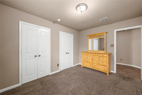 a bedroom with a bed and painting on the wall