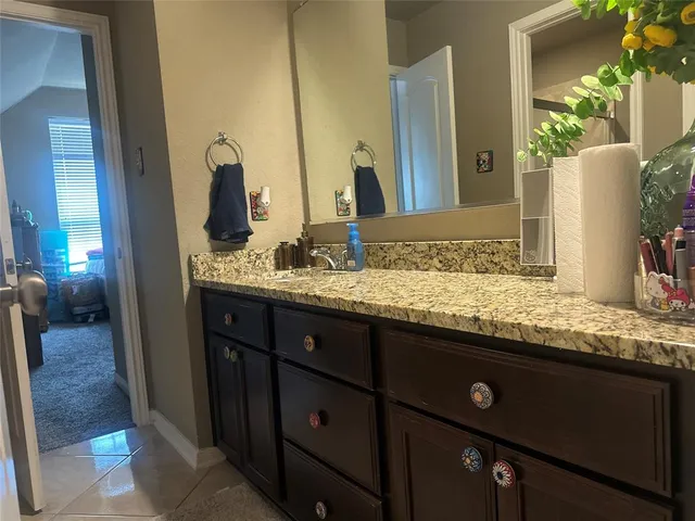 a bathroom with a granite countertop sink and a mirror
