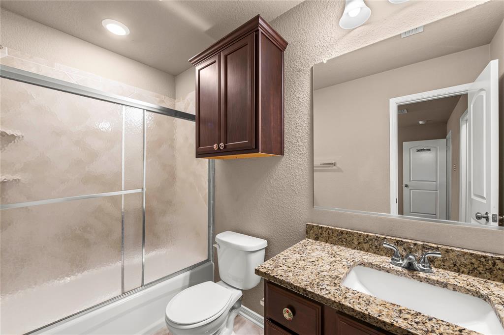 10420 Langham Drive Waco, TX 76708 - Photo 29 of 36 a bathroom with a granite countertop sink toilet and shower