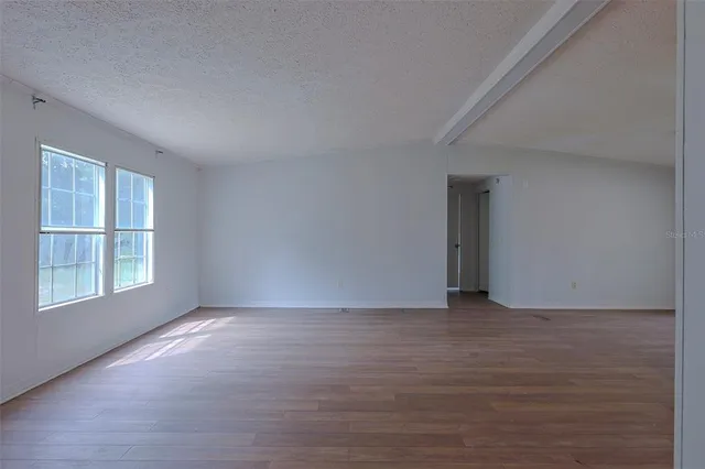 a view of a kitchen with wooden floor and a window