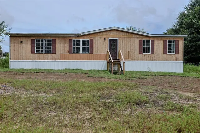 a view of a house with yard and a tree