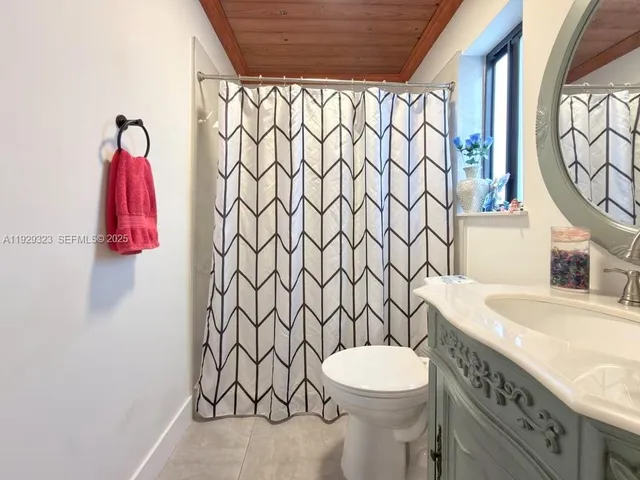 a bathroom with a toilet sink vanity and mirror