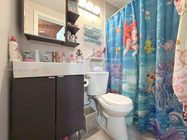 a bathroom with a sink toilet vanity and shower
