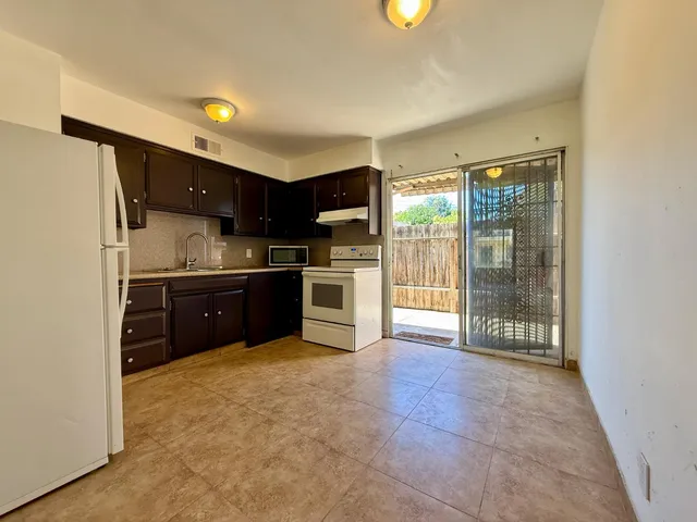 a view of a kitchen with a stove top oven and cabinets