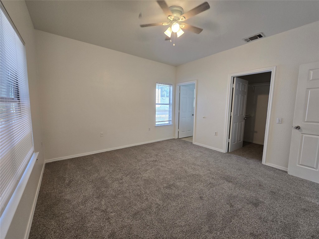 5404 Garden View Cove Austin, TX 78724 - Photo 12 of 28 an empty room with windows and fan