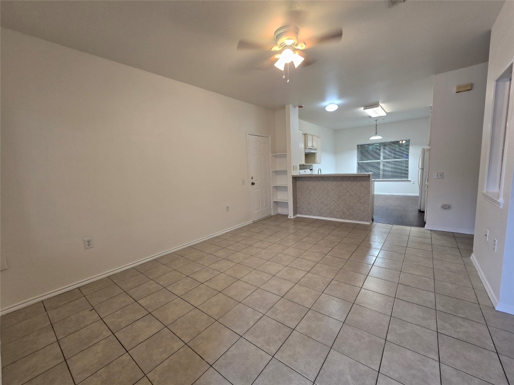 5404 Garden View Cove Austin, TX 78724 - Photo 2 of 28 an empty room with kitchen and chandelier fan
