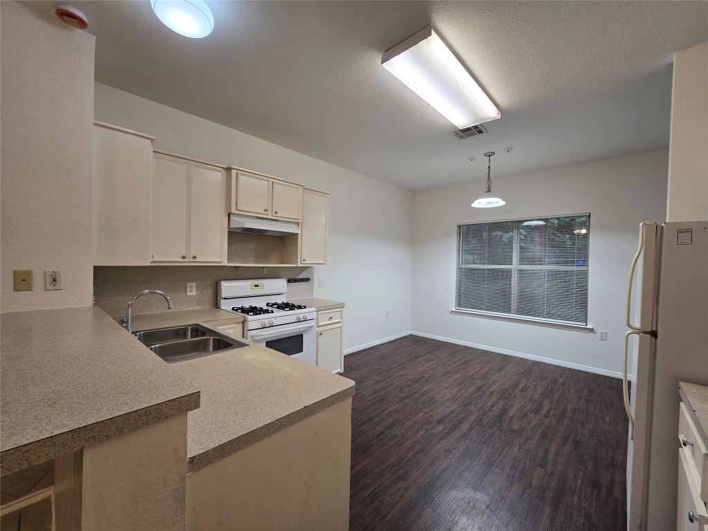 5404 Garden View Cove Austin, TX 78724 - Photo 4 of 28 a kitchen with a stove a sink and a refrigerator