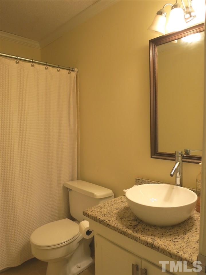 5305 Country Court Raleigh, NC 27609 - Photo 15 of 21 The updated hall Bath has a granite counter, vessel sink & tiled tub/shower.