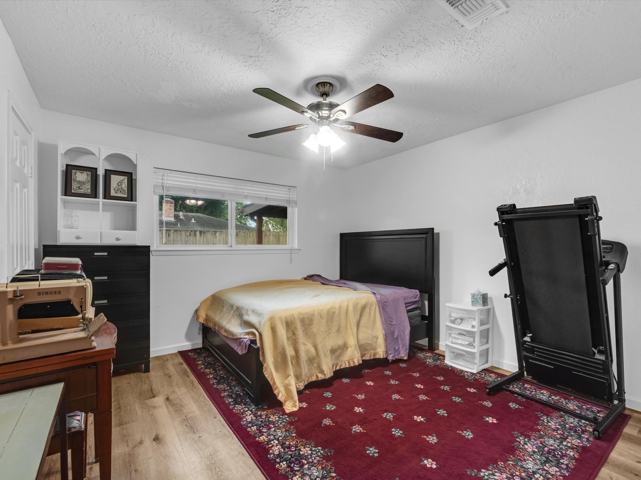 15714 Rill Lane Houston, TX 77062 - Photo 11 of 19 Your secondary bedroom features sleek flooring, neutral paint, ceiling fan with lighting, and a large window that lets in plenty of natural lighting.