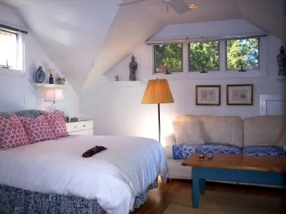 a bedroom with a bed lamps and a large window