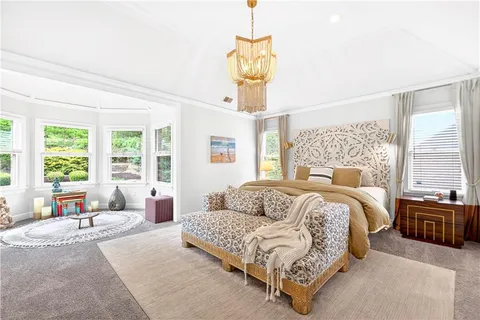 a spacious bedroom with a bed a couch and large windows