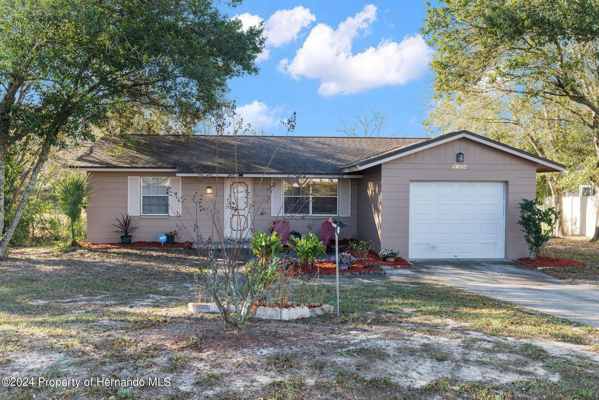 9124 Eldridge Road Spring Hill, FL 34608 - Photo 1 of 26 a front view of a house with garden