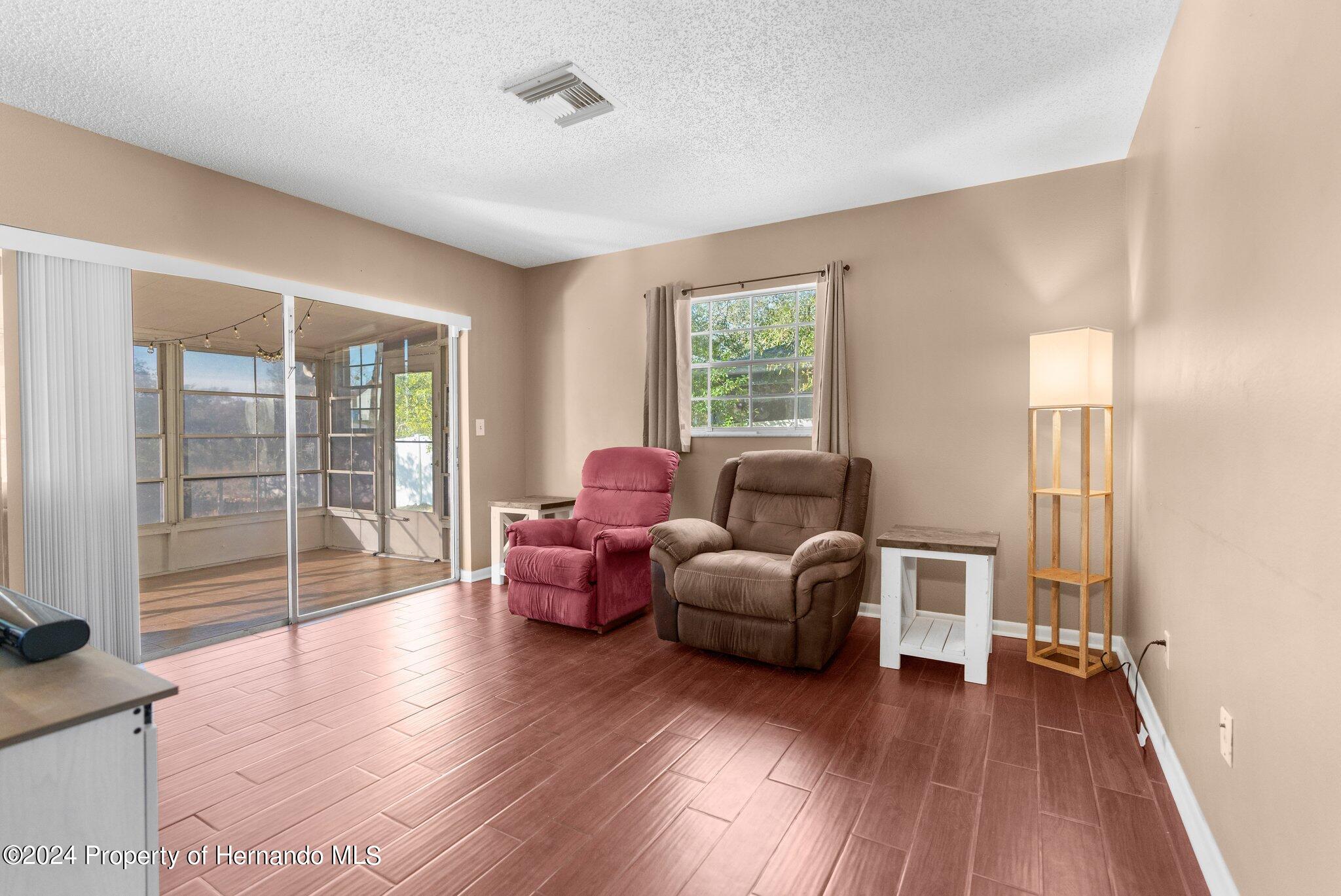 9124 Eldridge Road Spring Hill, FL 34608 - Photo 11 of 26 a living room with furniture and a wooden floor