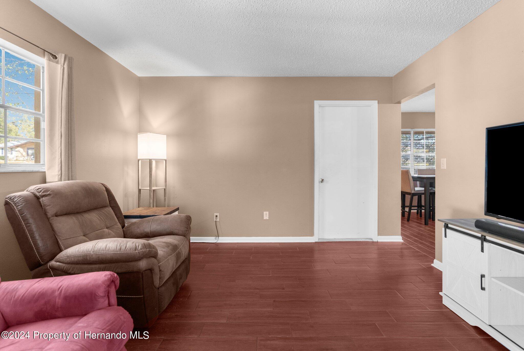 9124 Eldridge Road Spring Hill, FL 34608 - Photo 13 of 26 a living room with furniture and a flat screen tv