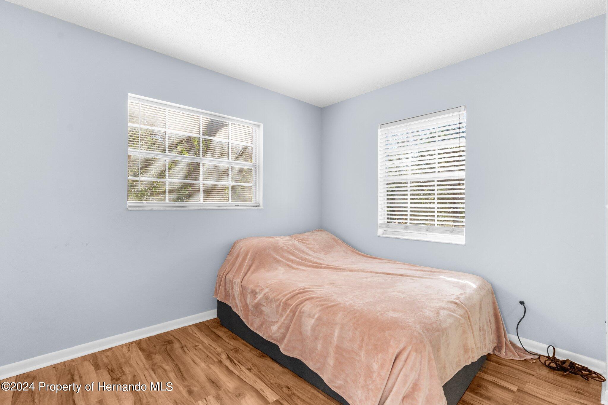 9124 Eldridge Road Spring Hill, FL 34608 - Photo 14 of 26 a bed sitting in a bedroom next to a window