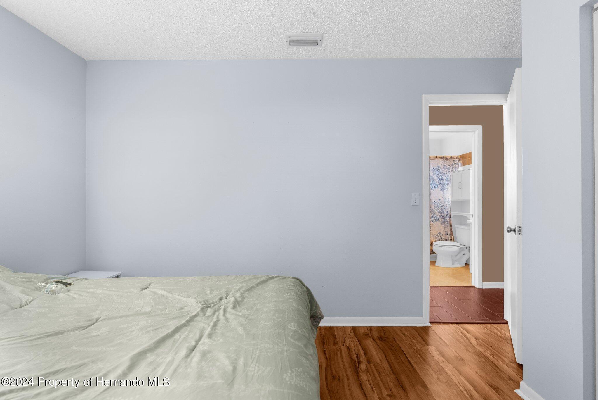 9124 Eldridge Road Spring Hill, FL 34608 - Photo 18 of 26 a view of a bedroom with wooden floor and bedroom