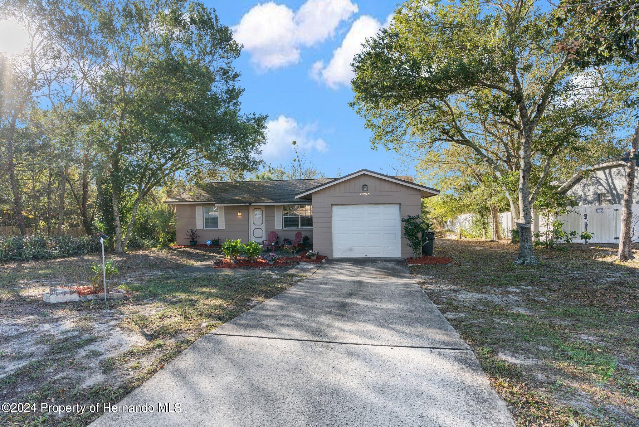 9124 Eldridge Road Spring Hill, FL 34608 - Photo 2 of 26 a view of a house with a yard and tree s