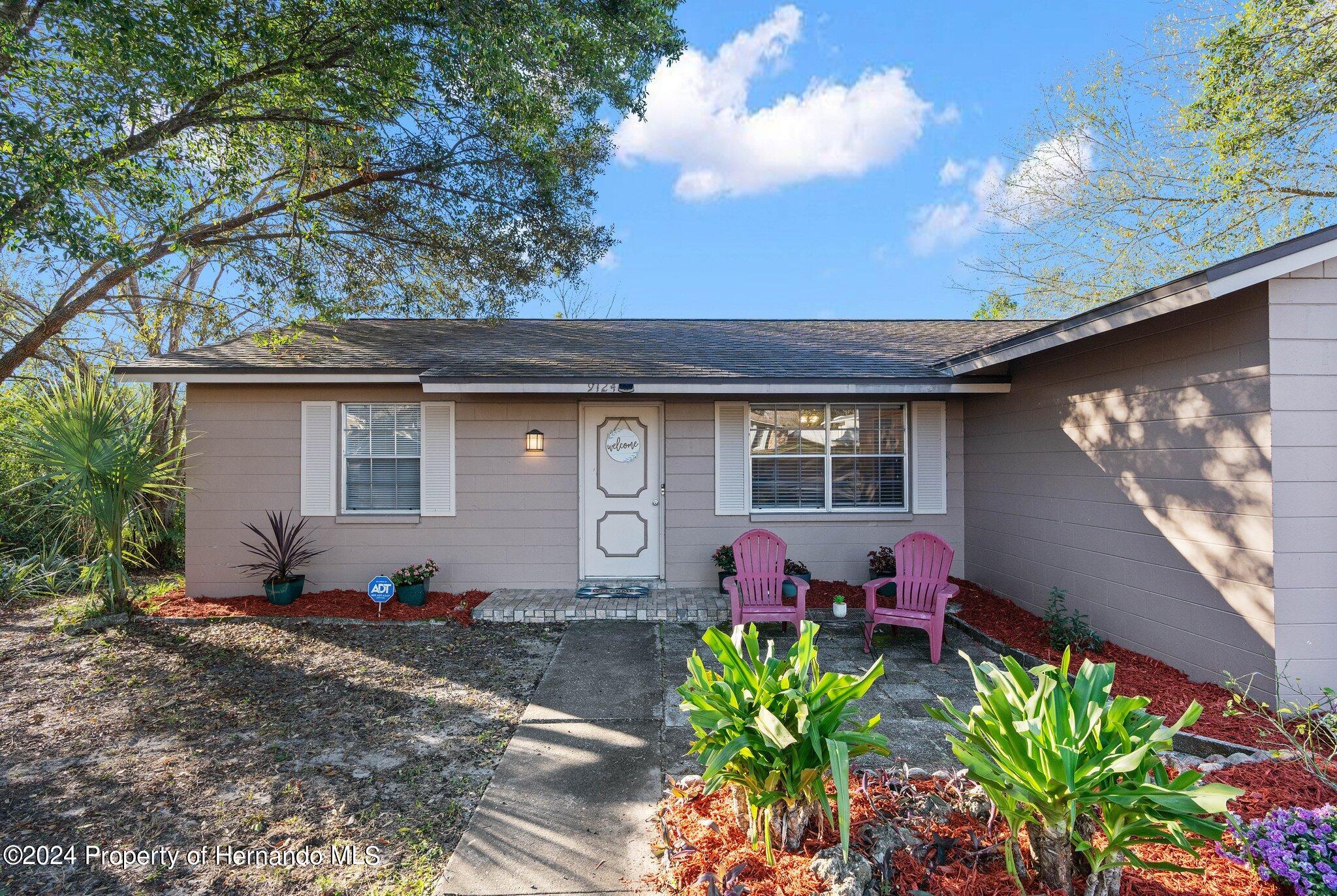 9124 Eldridge Road Spring Hill, FL 34608 - Photo 3 of 26 a front view of a house with chairs