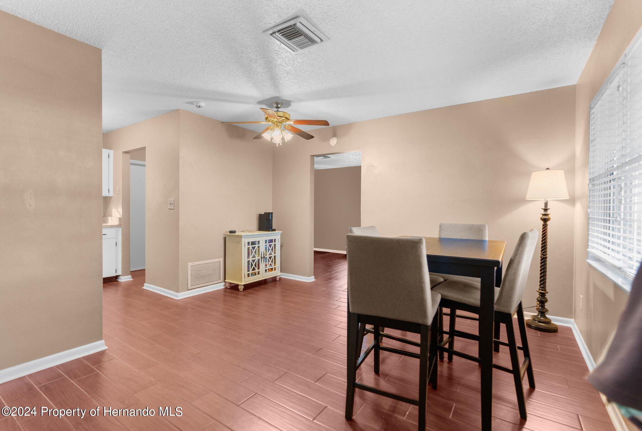 9124 Eldridge Road Spring Hill, FL 34608 - Photo 4 of 26 a view of a dining room with furniture and wooden floor