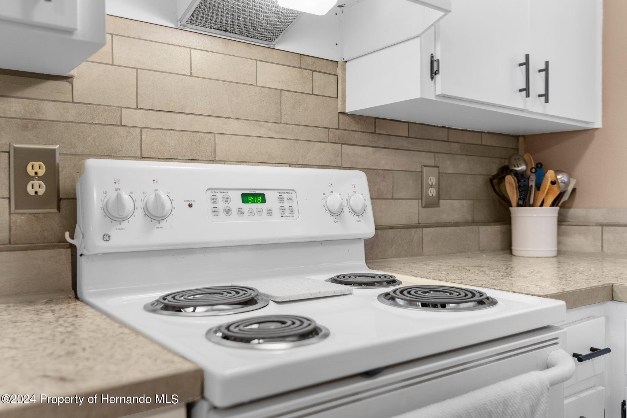 9124 Eldridge Road Spring Hill, FL 34608 - Photo 8 of 26 a white stove top oven sitting inside of a kitchen