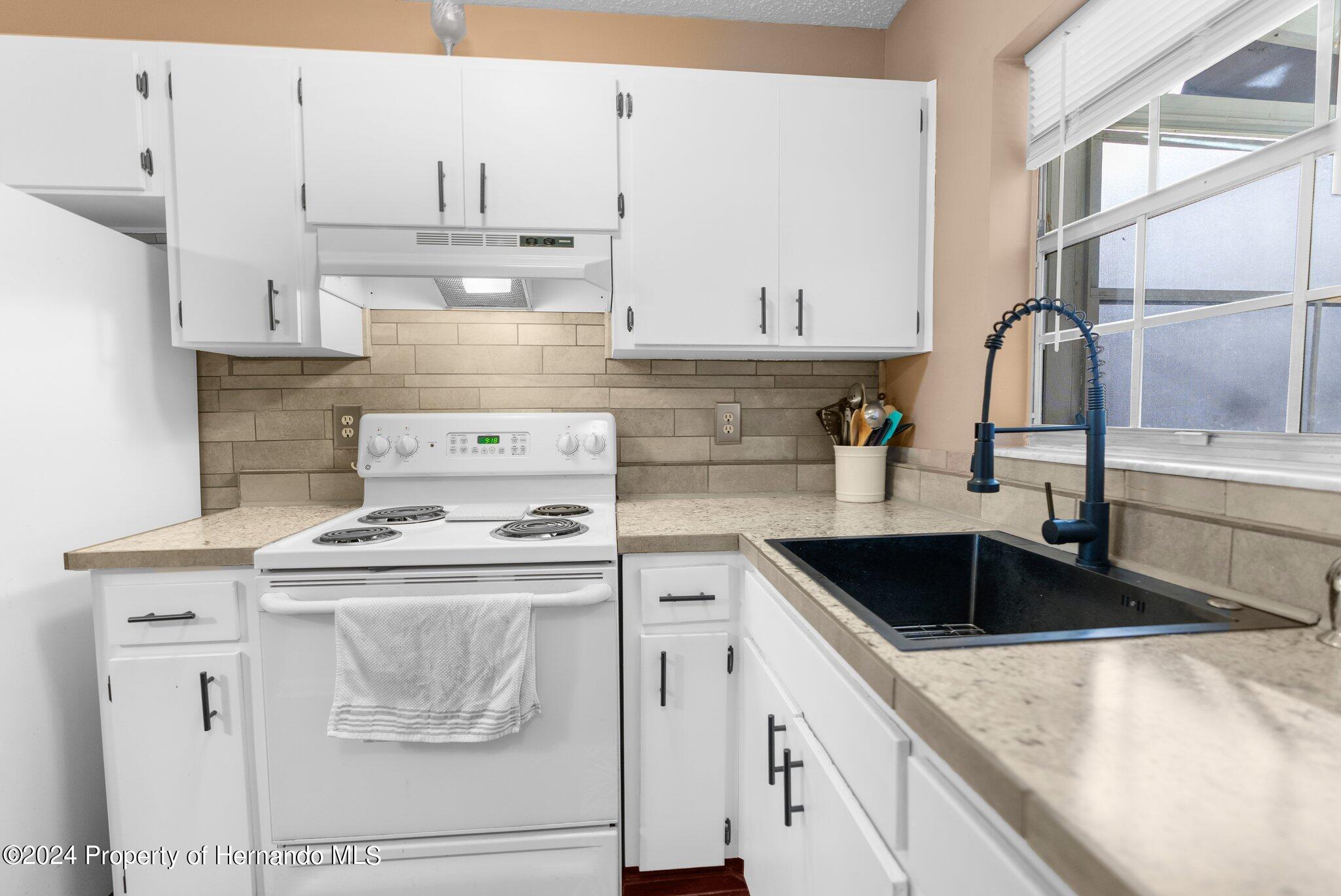 9124 Eldridge Road Spring Hill, FL 34608 - Photo 9 of 26 a kitchen with a stove and a sink