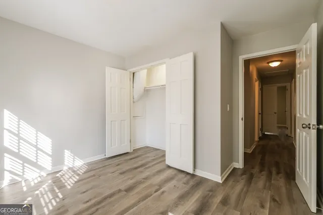 a view of a room with wooden floor and a bathroom