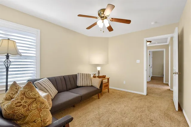 a living room with furniture and a ceiling fan