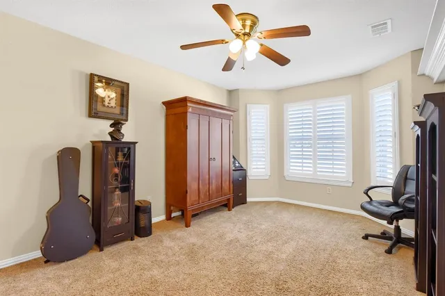 a view of a workspace with furniture and a window