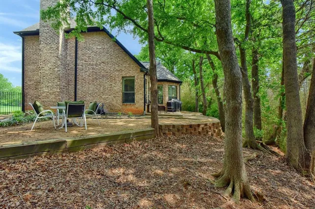 a view of a house with backyard and trees