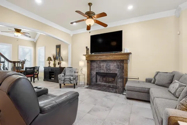 a living room with furniture a flat screen tv and a fireplace