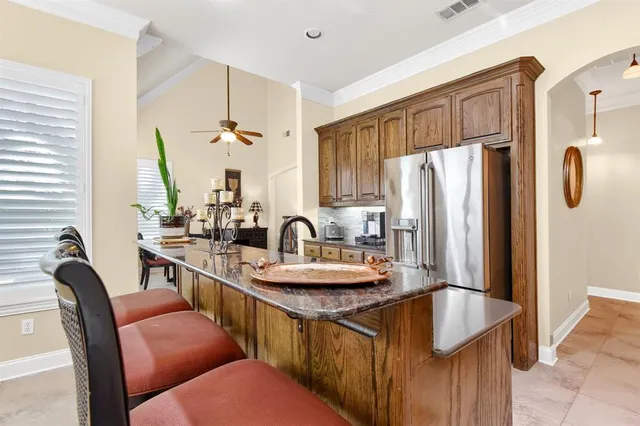 a kitchen with stainless steel appliances granite countertop a sink refrigerator and cabinets