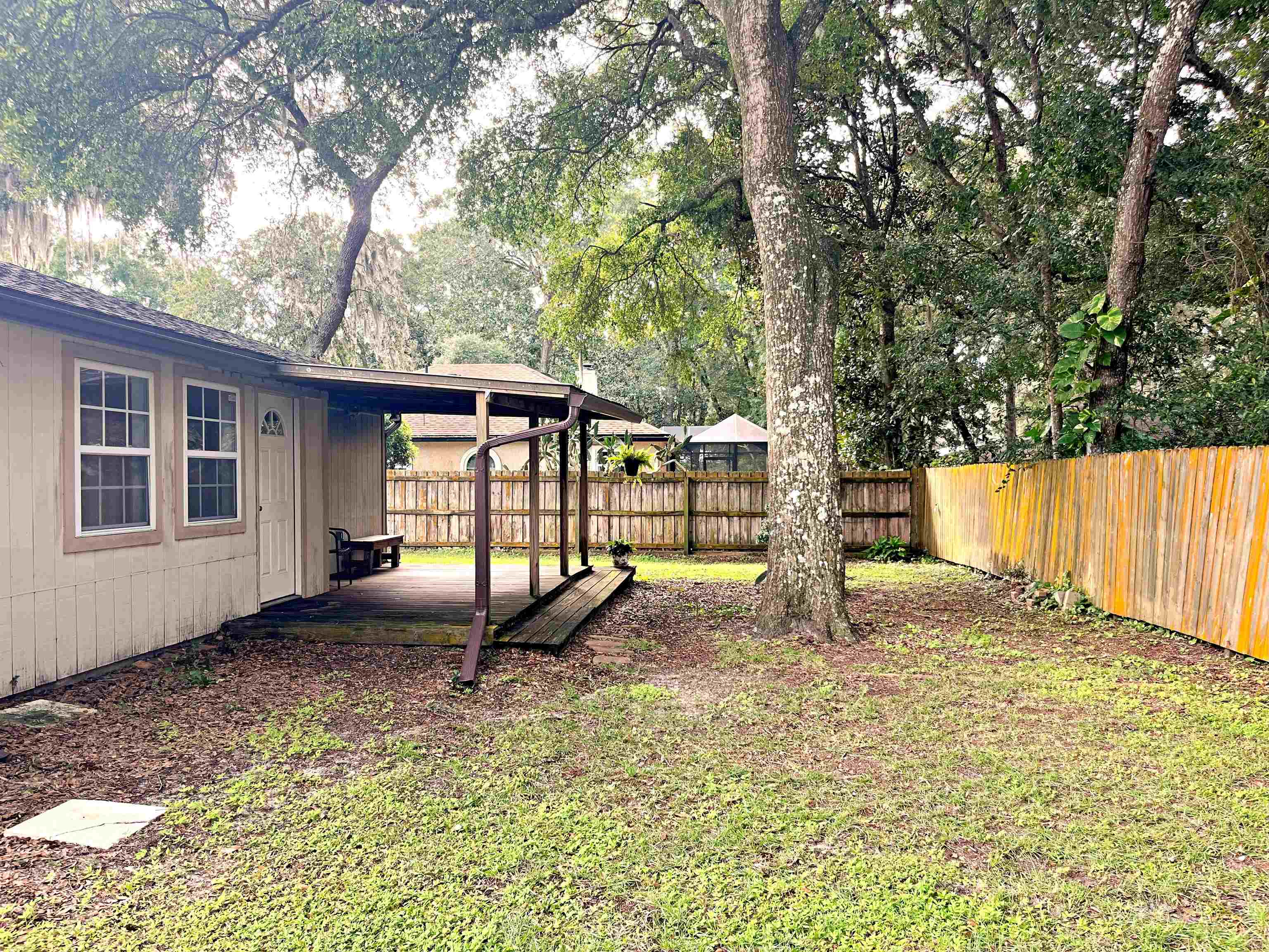 424 Orchis Road St. Augustine, FL 32086 - Photo 16 of 24 a view of a backyard with large trees and wooden fence