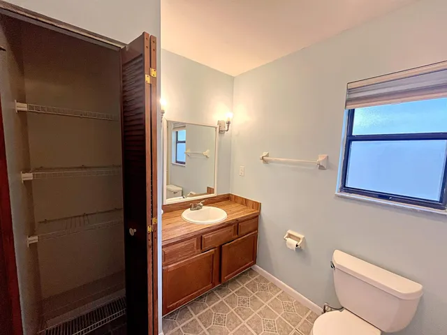 a bathroom with a granite countertop sink and a toilet
