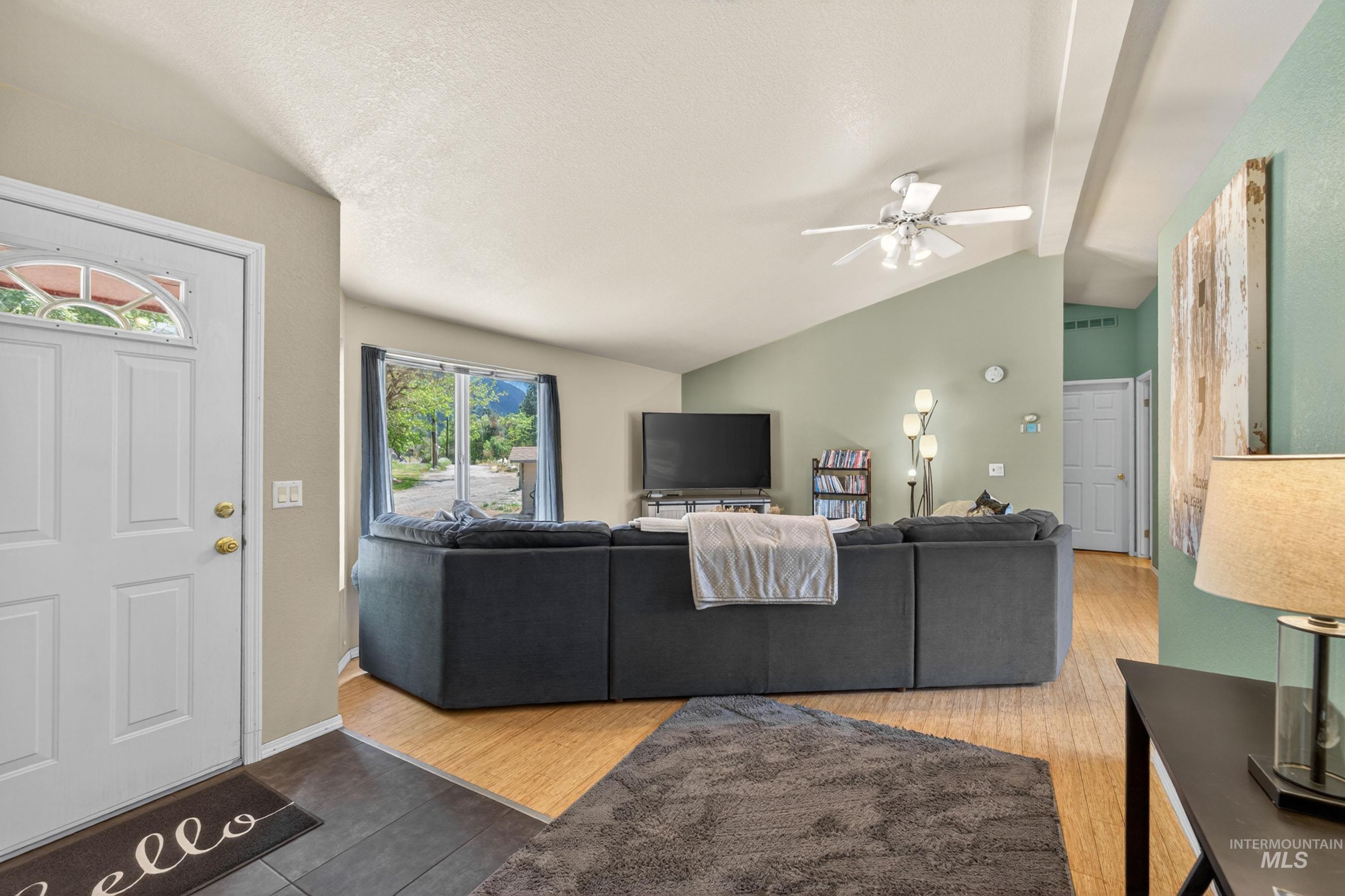 151 Cow Creek Road Lucile, ID 83542 - Photo 7 of 50 Open living area featuring vaulted ceilings, a ceiling fan, and wood-finish flooring