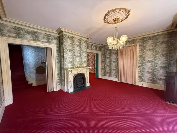 a view of empty room with a fireplace and chandelier