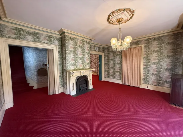 a view of empty room with a fireplace and chandelier
