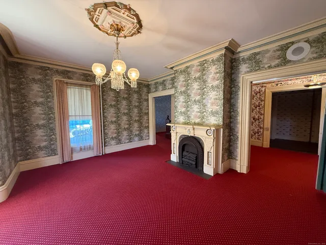 a view of a livingroom with a fireplace window and chandelier
