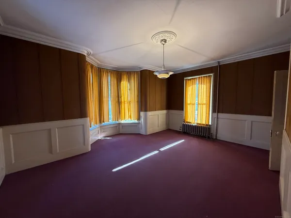 a view of an empty room with window and cabinet