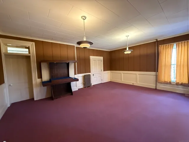 an empty room with windows and fireplace