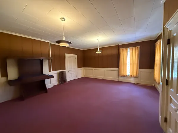an empty room with wooden floor and a window