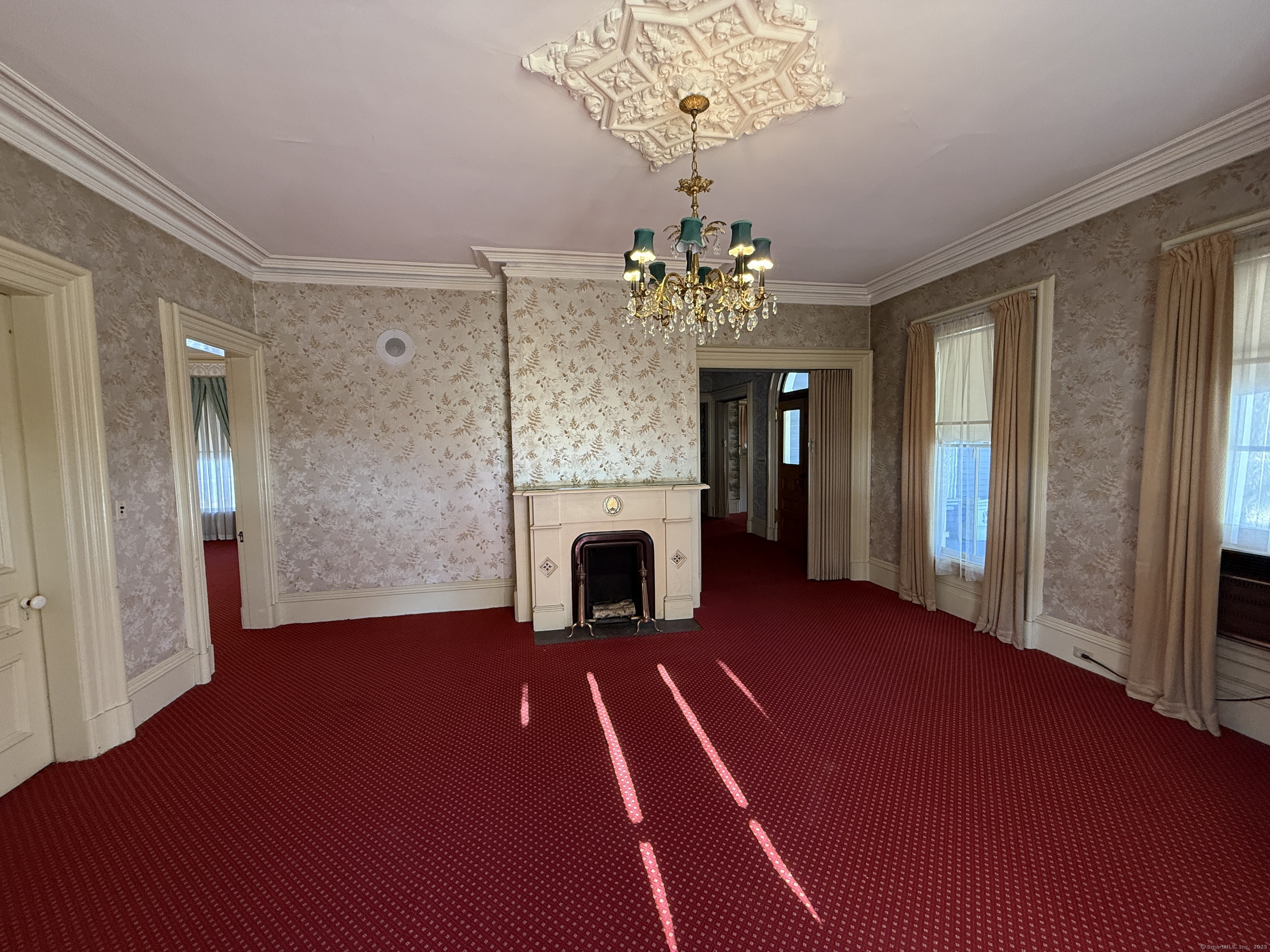 55 Walnut Street Winchester, CT 06098 - Photo 9 of 37 a view of a livingroom with a fireplace a chandelier and wooden floor