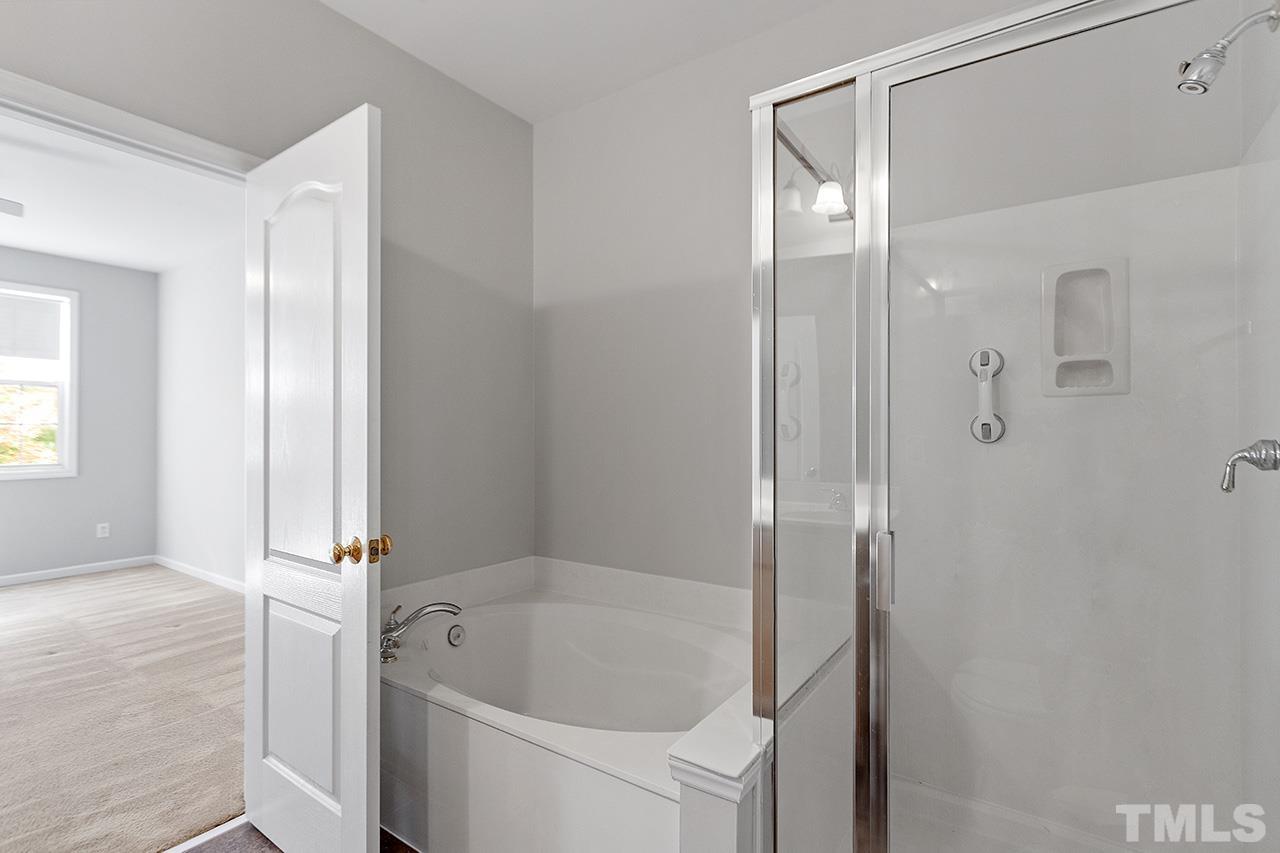 1401 Basinger Court Raleigh, NC 27612 - Photo 18 of 32 a bathroom with a bathtub and a shower