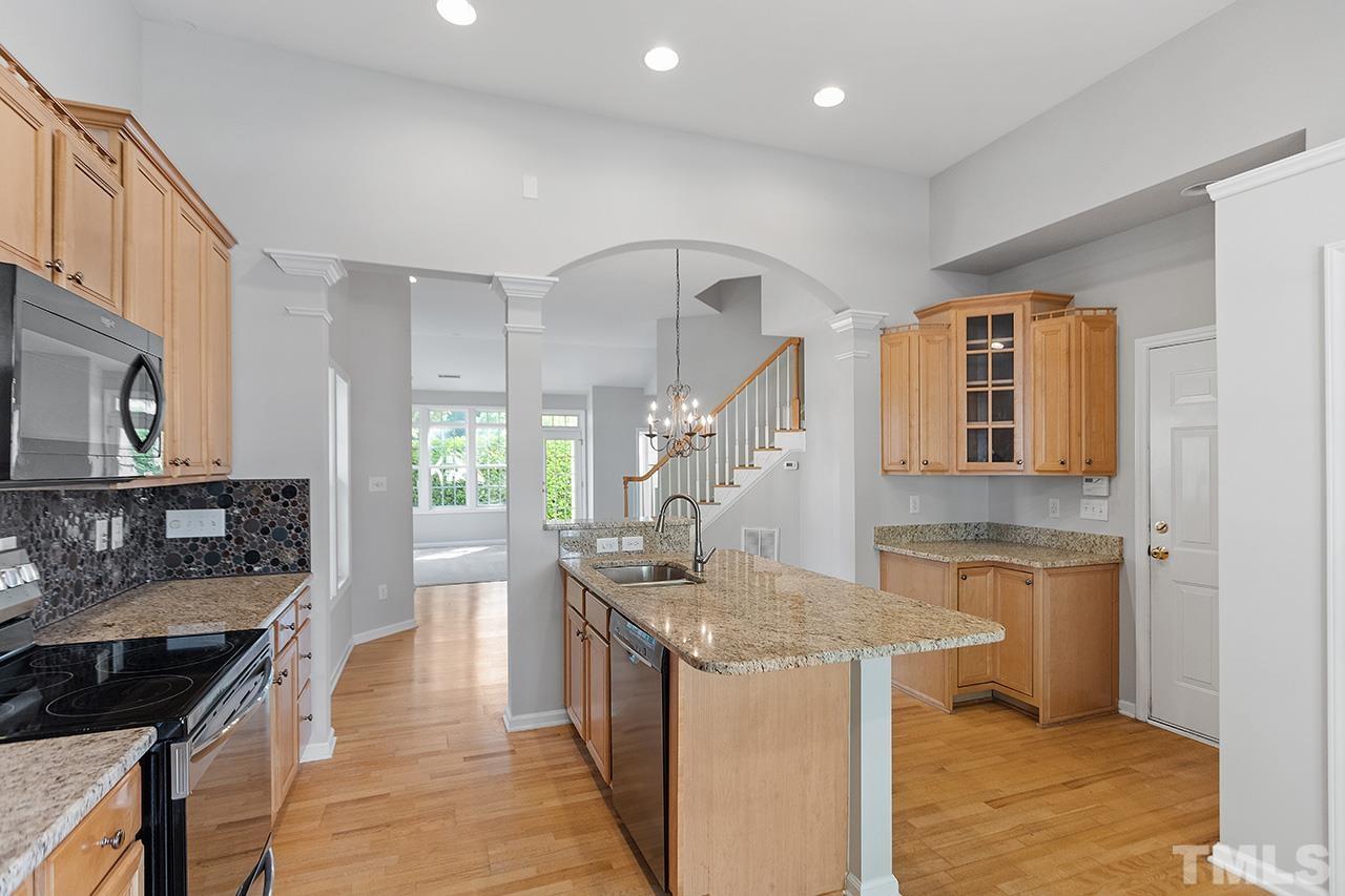 1401 Basinger Court Raleigh, NC 27612 - Photo 23 of 32 a kitchen with stainless steel appliances granite countertop a stove and a sink