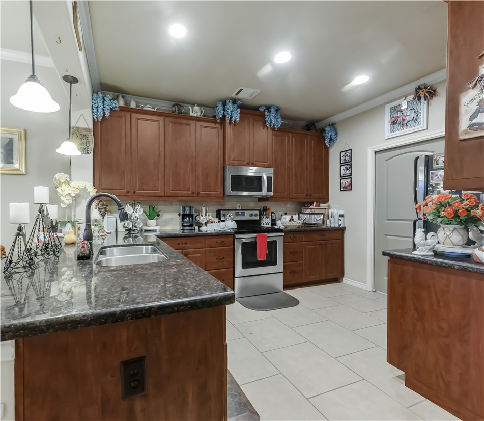 3815 Harvey Road College Station, TX 77845 - Photo 12 of 24 a kitchen with stainless steel appliances granite countertop a sink counter space cabinets and a counter top space