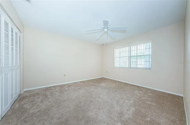 an empty room with windows and fan