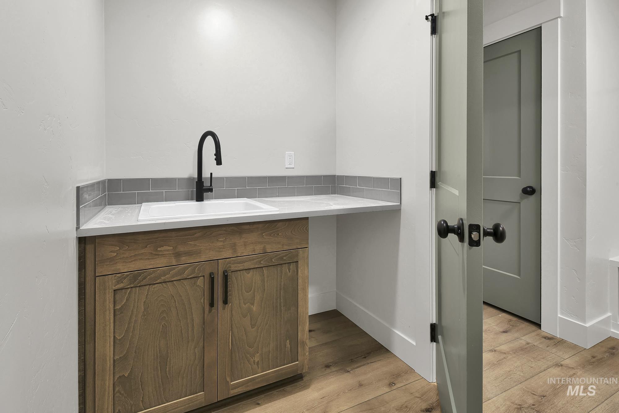 1130 Velvet Loop Wilder, ID 83676 - Photo 34 of 35 Utility sink with a matte black faucet, set within a light-toned countertop and wood-finish cabinetry